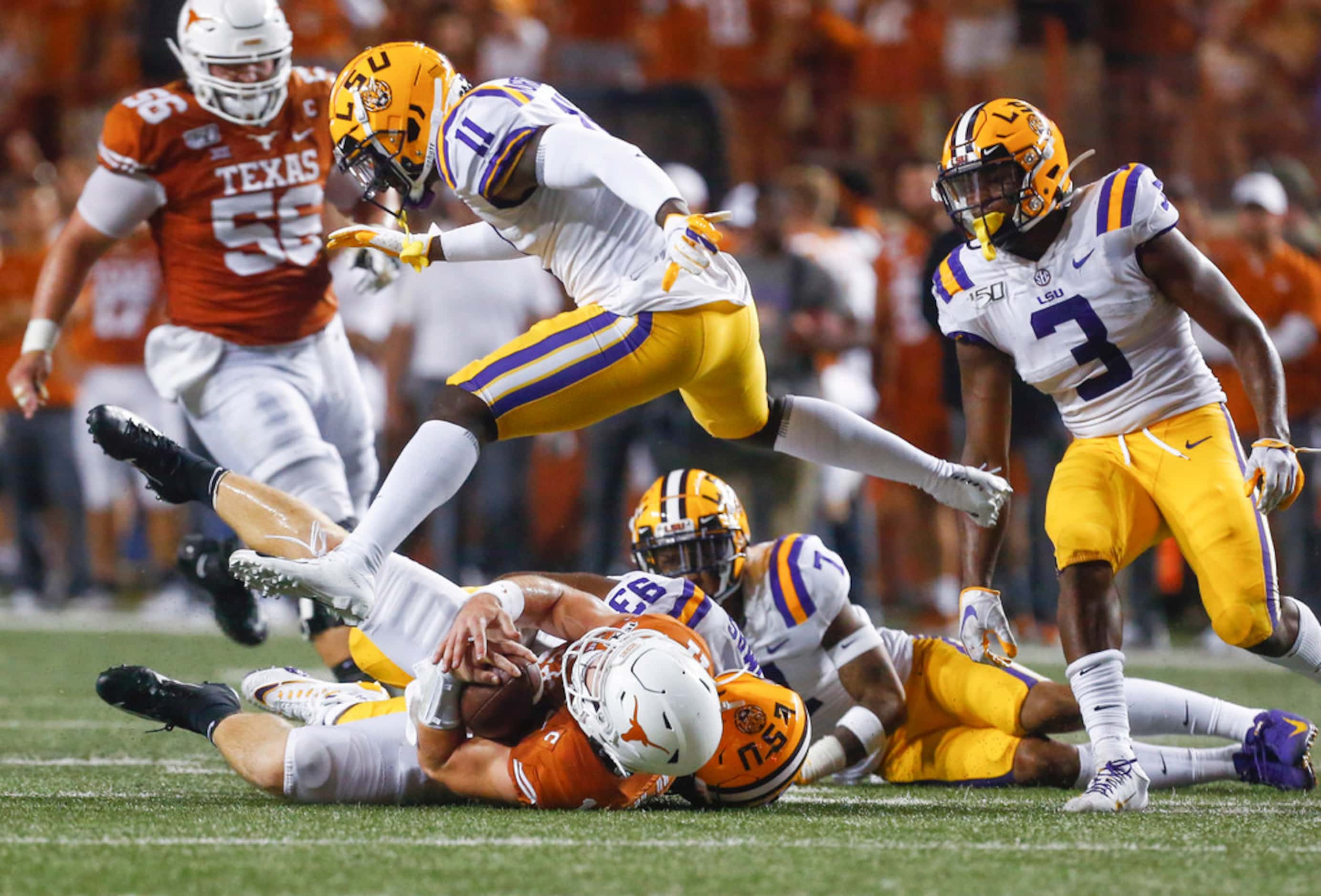 LSU Tigers safety Eric Monroe (11) goes airborne as defensive end Justin Thomas (93) brings...