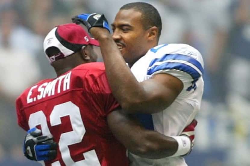 Emmitt Smith greets former teammate Darren Woodson before the Cowboys' 24-7 victory Sunday...