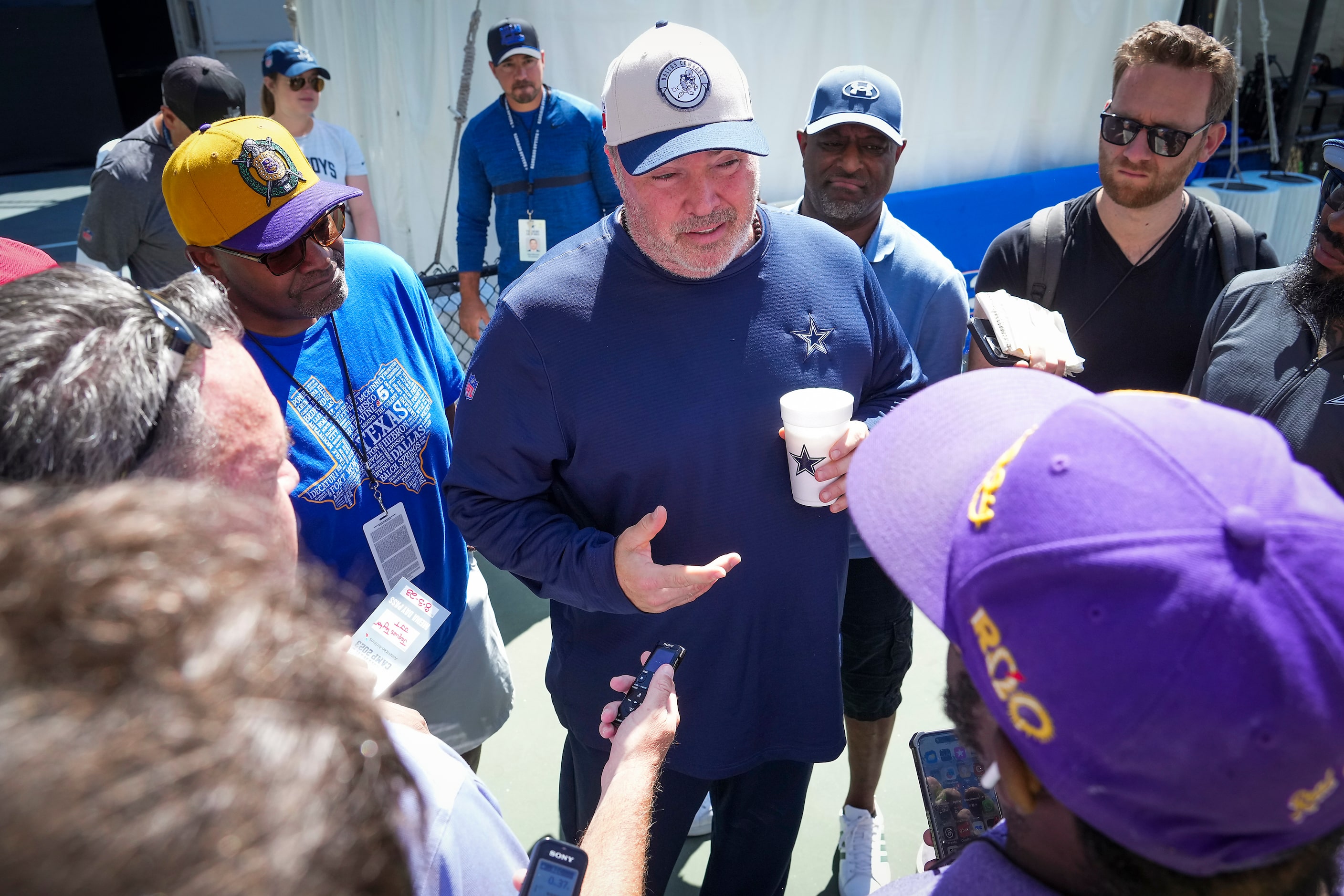 Dallas Cowboys head coach Mike McCarthy talks with reporters before a training camp practice...