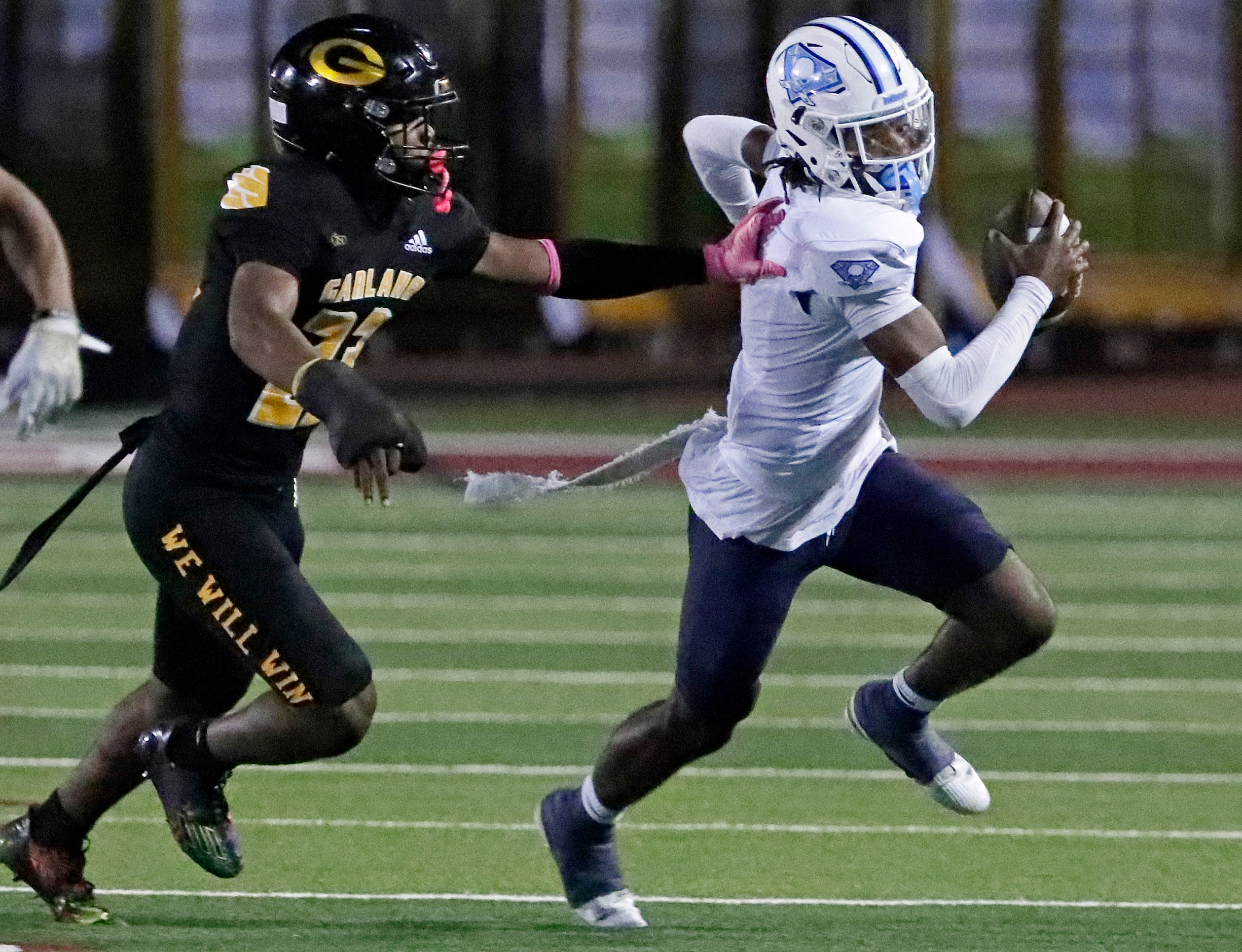 Wylie East High School quarterback Howard Fisher IV (4) is chased by Garland High School...