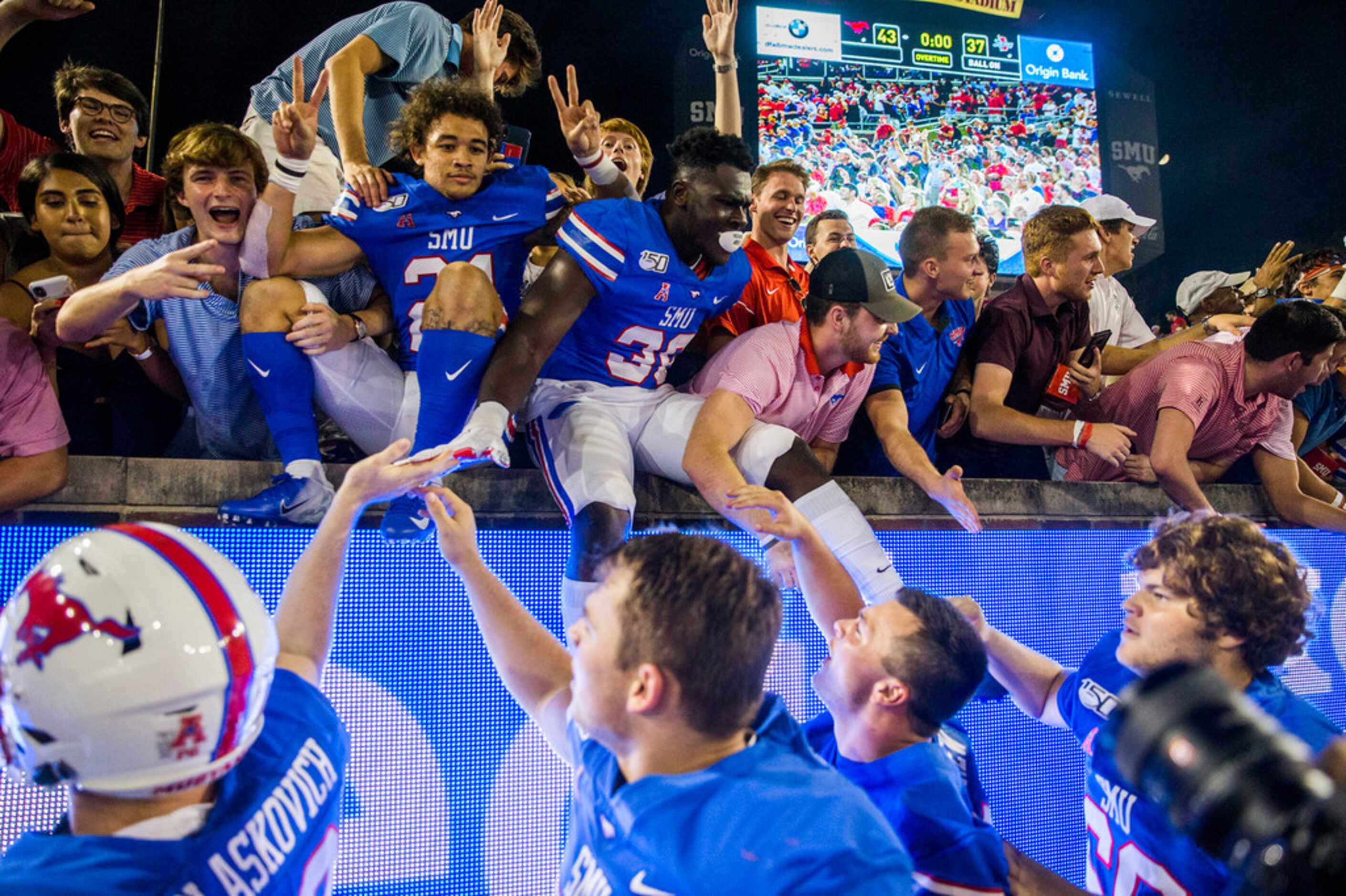 SMU players and fans celebrate a 43-37 win against Tulsa in triple overtime on Saturday,...