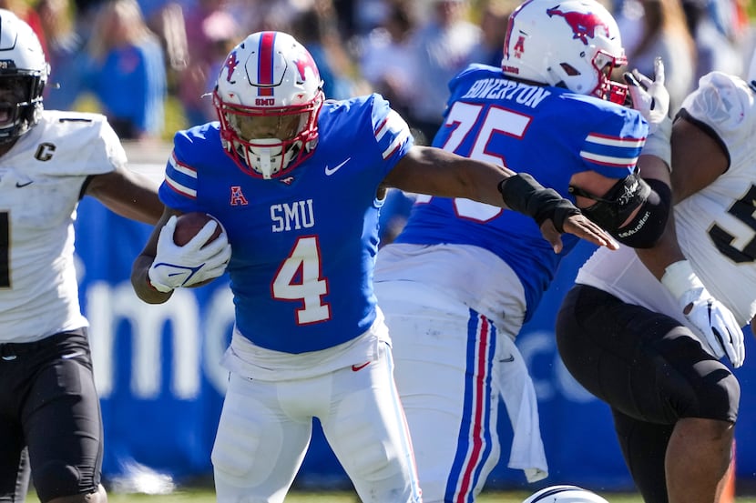 SMU running back Tre Siggers (4) slips away from UCF linebacker Tatum Bethune (15) during...