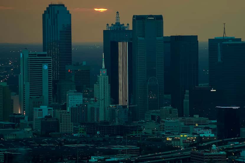 Aerial view of the sun setting behind the downtown skyline on Wednesday, Sept. 16, 2020, in...
