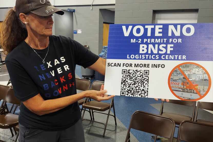 Gunter resident Angie Rich holds up a sign at a July public meeting urging City Council...