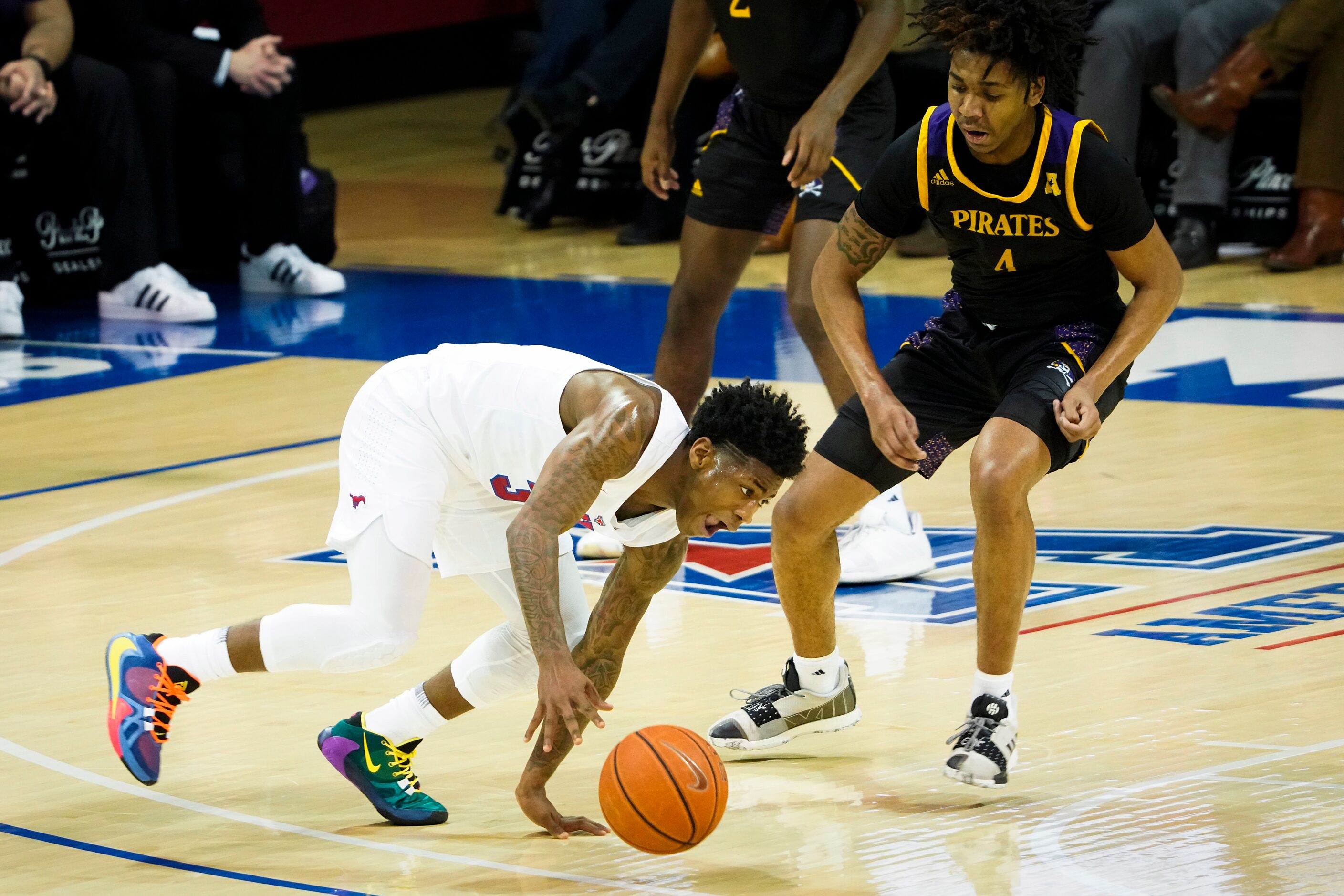 SMU guard Kendric Davis (3) keeps his balance as East Carolina forward Brandon Suggs (4)...