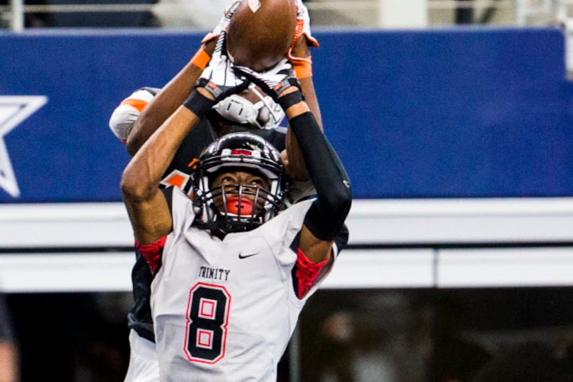 Euless Trinity defensive back John Davis (8) breaks up a pass in the end zone intended for...