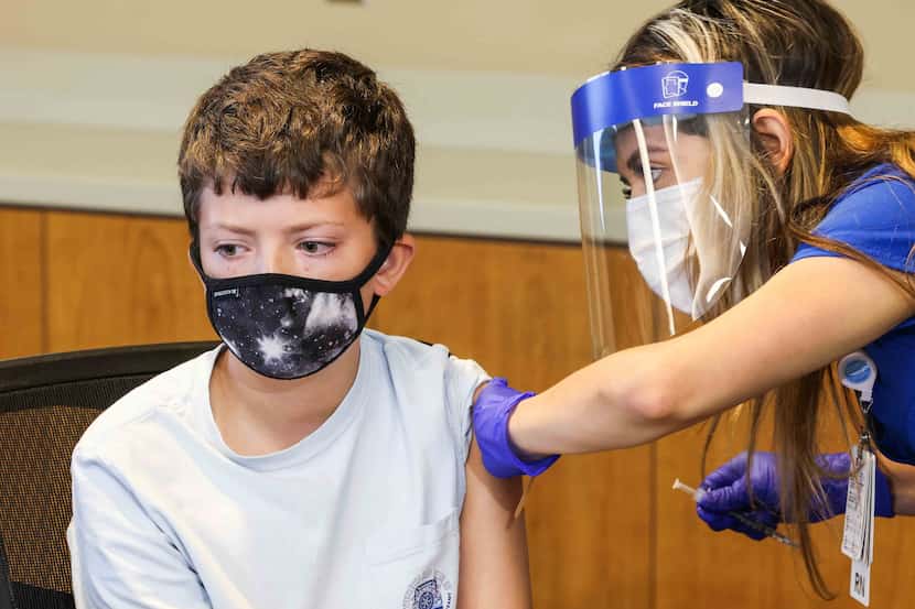 Henry Ricketts, 12, receives a COVID-19 vaccine as one of the first minors under 16 years...