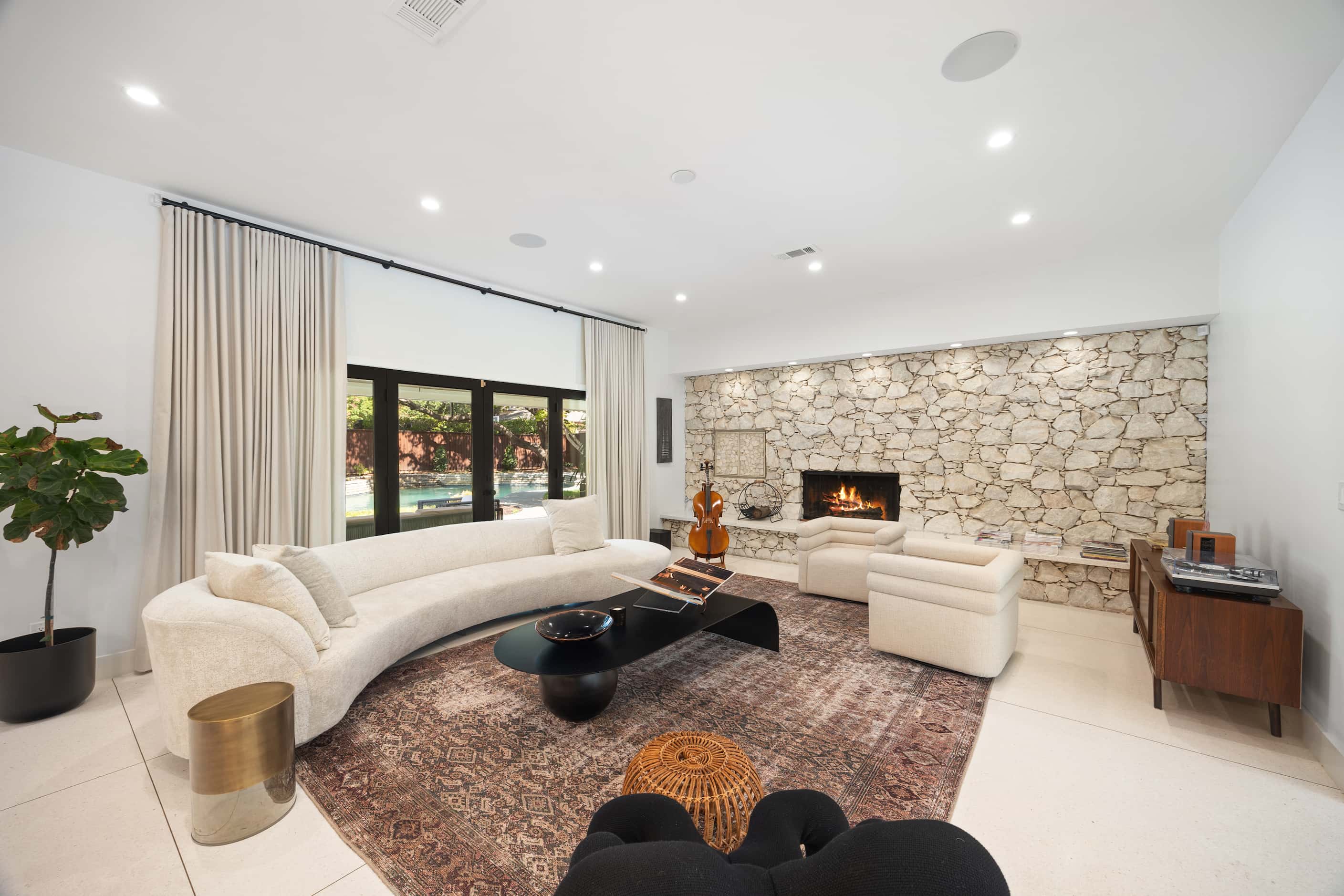 Living room in midcentury home with modern and contemporary furniture, original stone fireplace