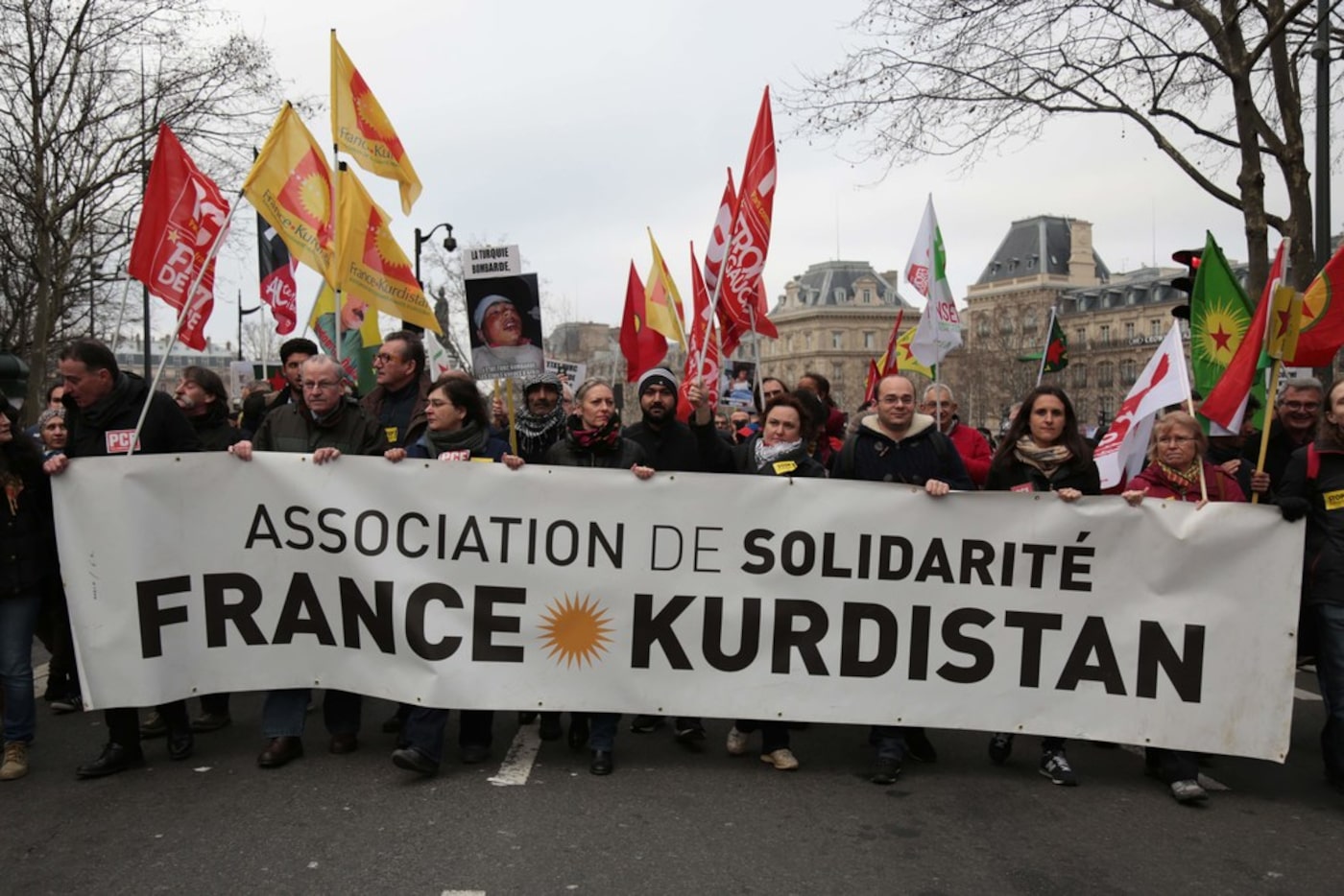 People carry a banner during a demonstration against Turkey's military action in the Syrian...