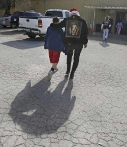  Gail McIntosh (right) talked with tornado survivor Junior Santillano, 10, as they headed...