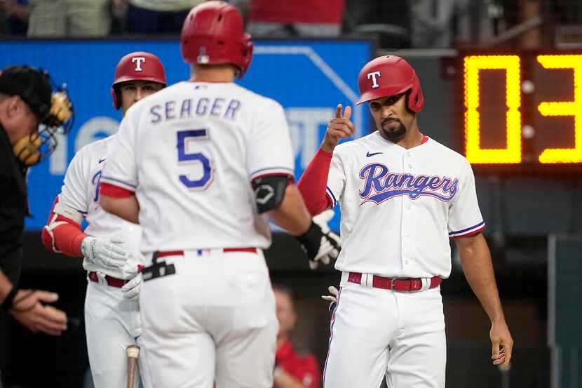 Texas Rangers' Corey Seager (5) and Marcus Semien, right, celebrate at the plate after...