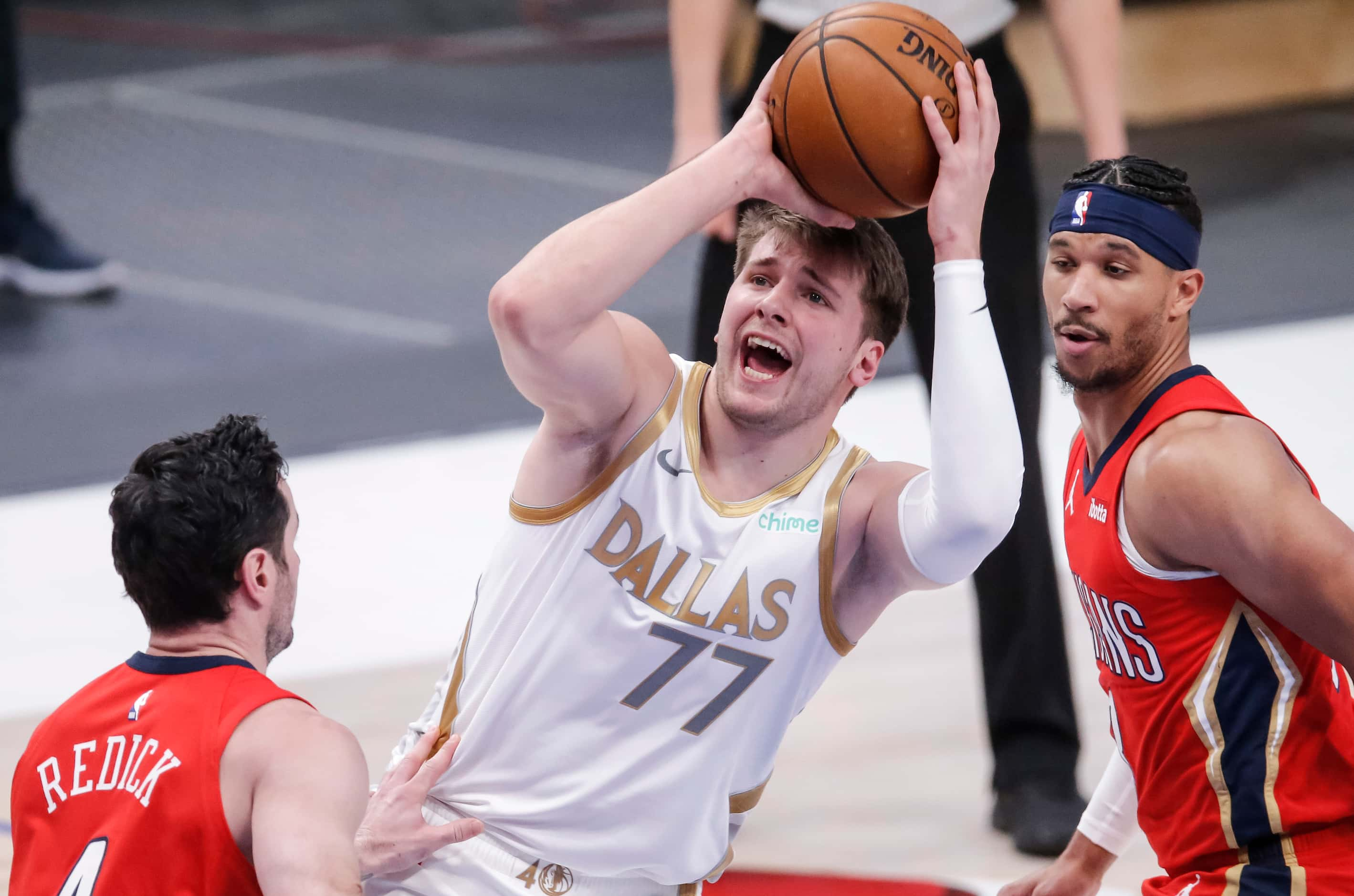 Dallas Mavericks guard Luka Doncic (77) attempts a shot as New Orleans Pelicans guards JJ...