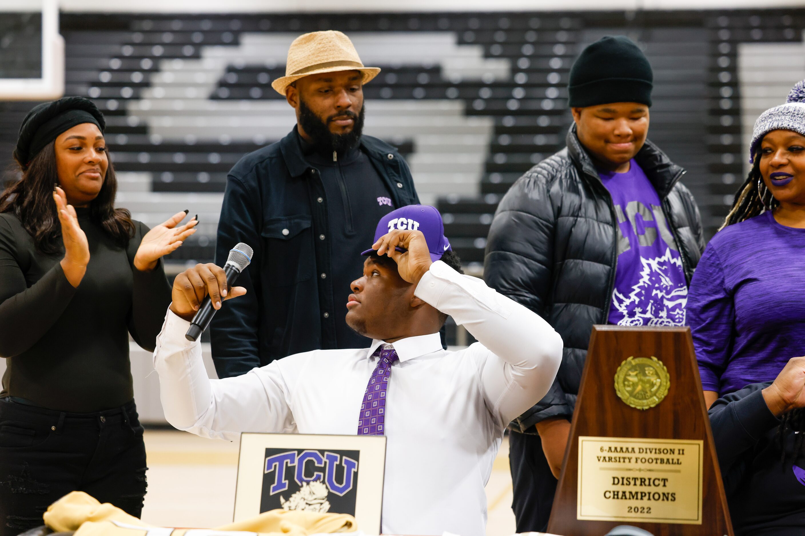 South Oak Cliff football player Narado Stoker (center) places a Texas Christian University...