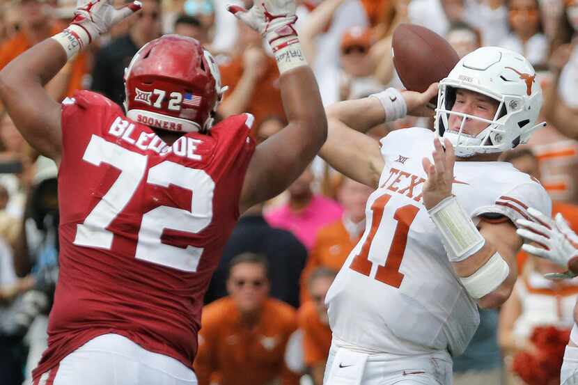 Texas Longhorns quarterback Sam Ehlinger (11) throws a pass under pressure from Oklahoma...