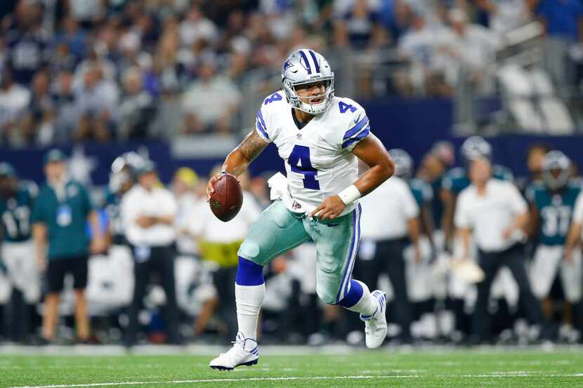 Dallas Cowboys quarterback Dak Prescott (4) charges to the outside looking for a receiver in...