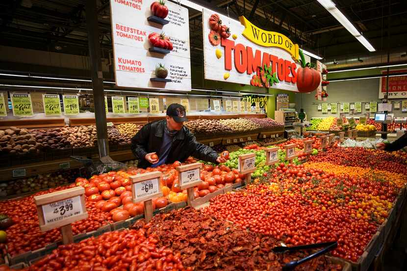 Shoppers look over tomatoes in the produce section at Central Market on Lovers Lane in Dallas.