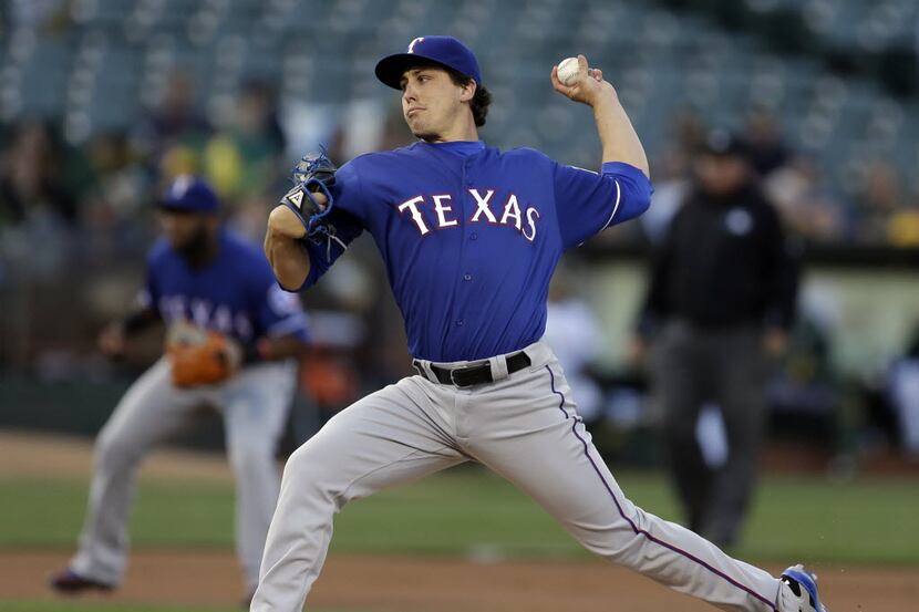 Texas Rangers pitcher Derek Holland works against the Oakland Athletics in the first inning...