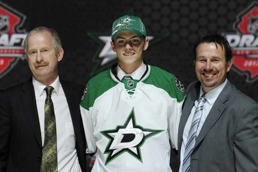Jason Dickinson, a center, stands with officials from the Dallas Stars sweater after being...