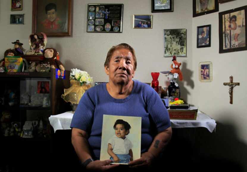 Bessie Rodríguez, la madre de Santos Rodríguez, sostiene una pintura de su hijo en su casa...