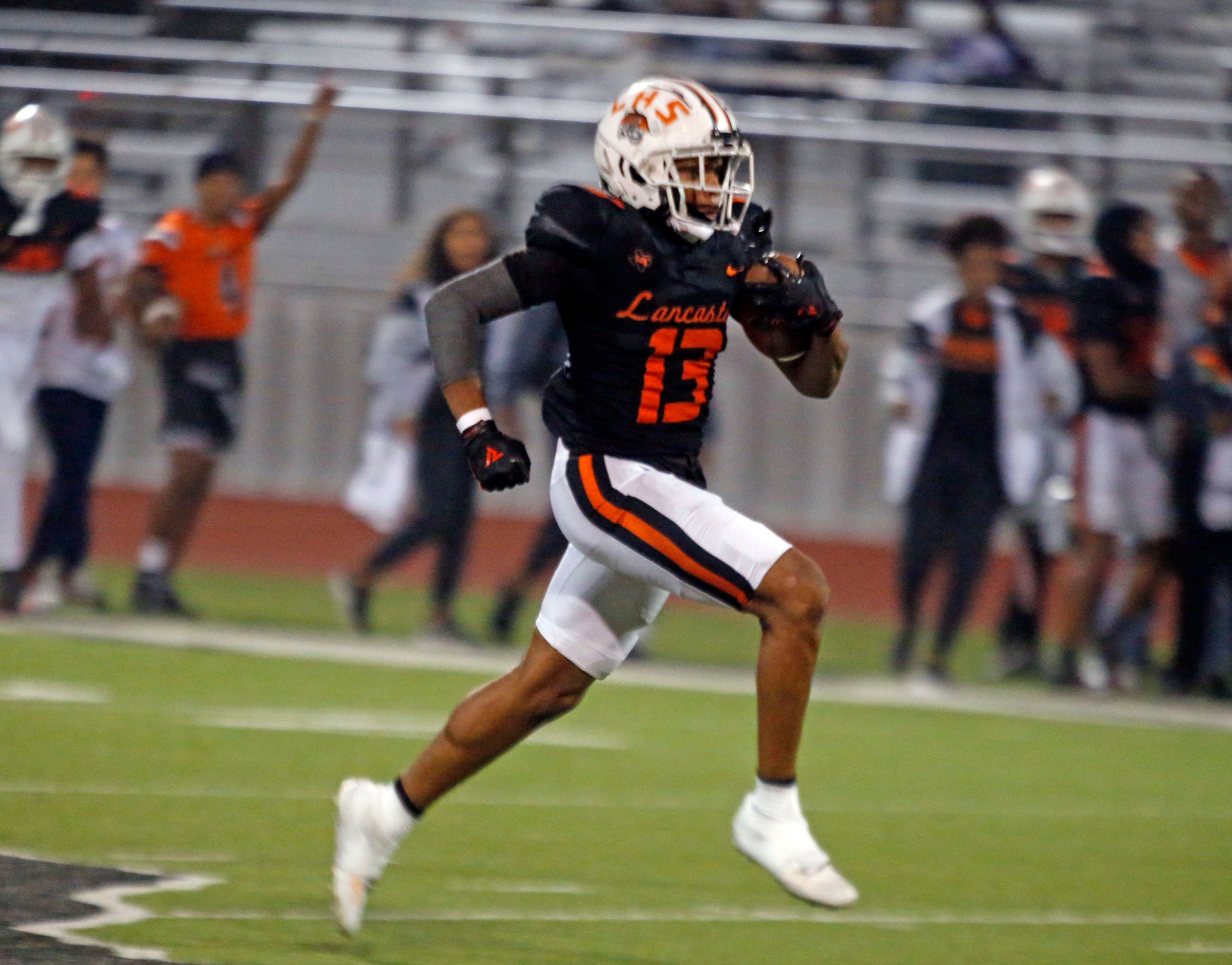 Lancaster High’s Victor Scott (13) breaks loose for a long touchdown run during the first...