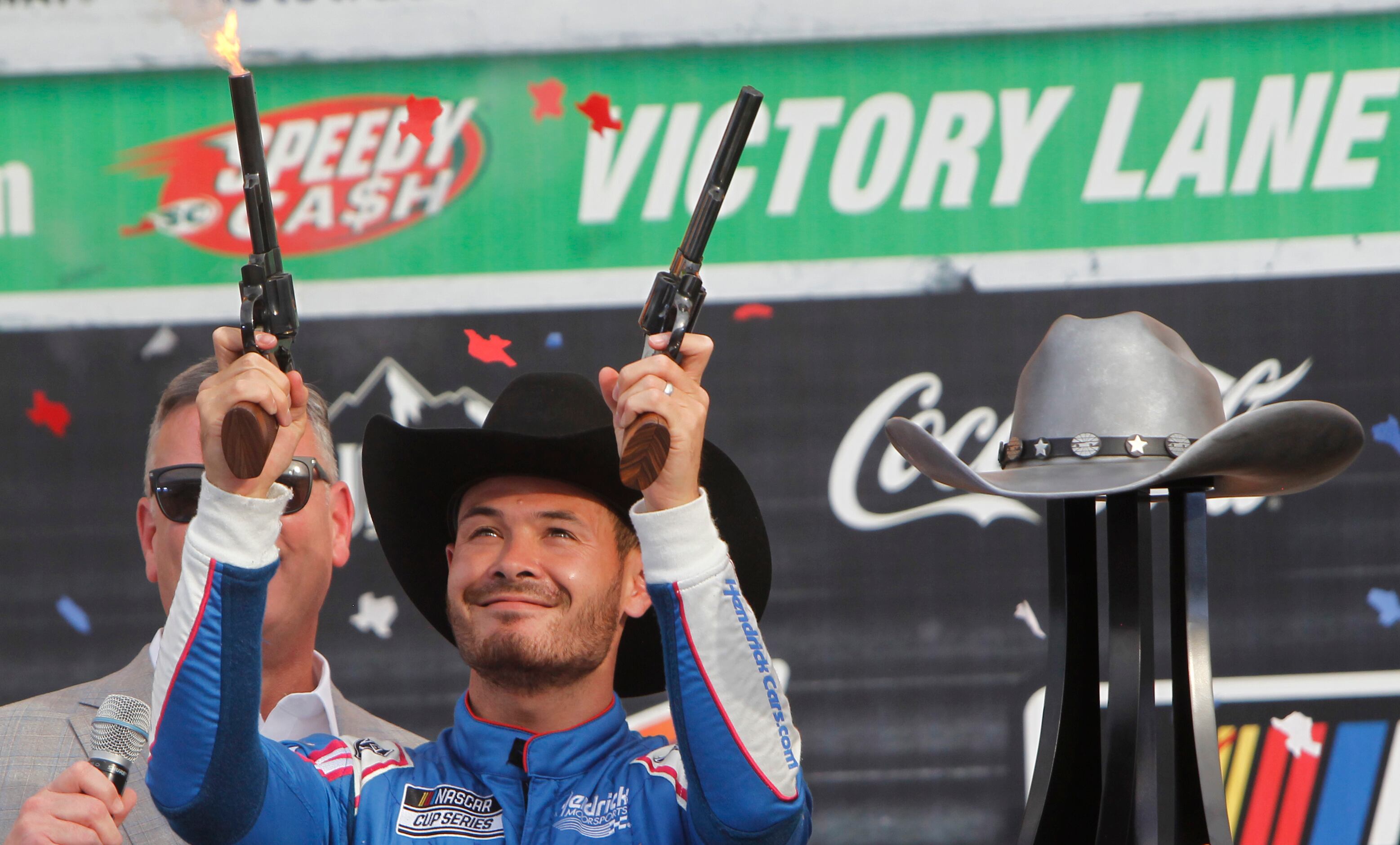 Kyle Larson fires a pair of pistols in Victory Lane as he celebrated his win after driving...