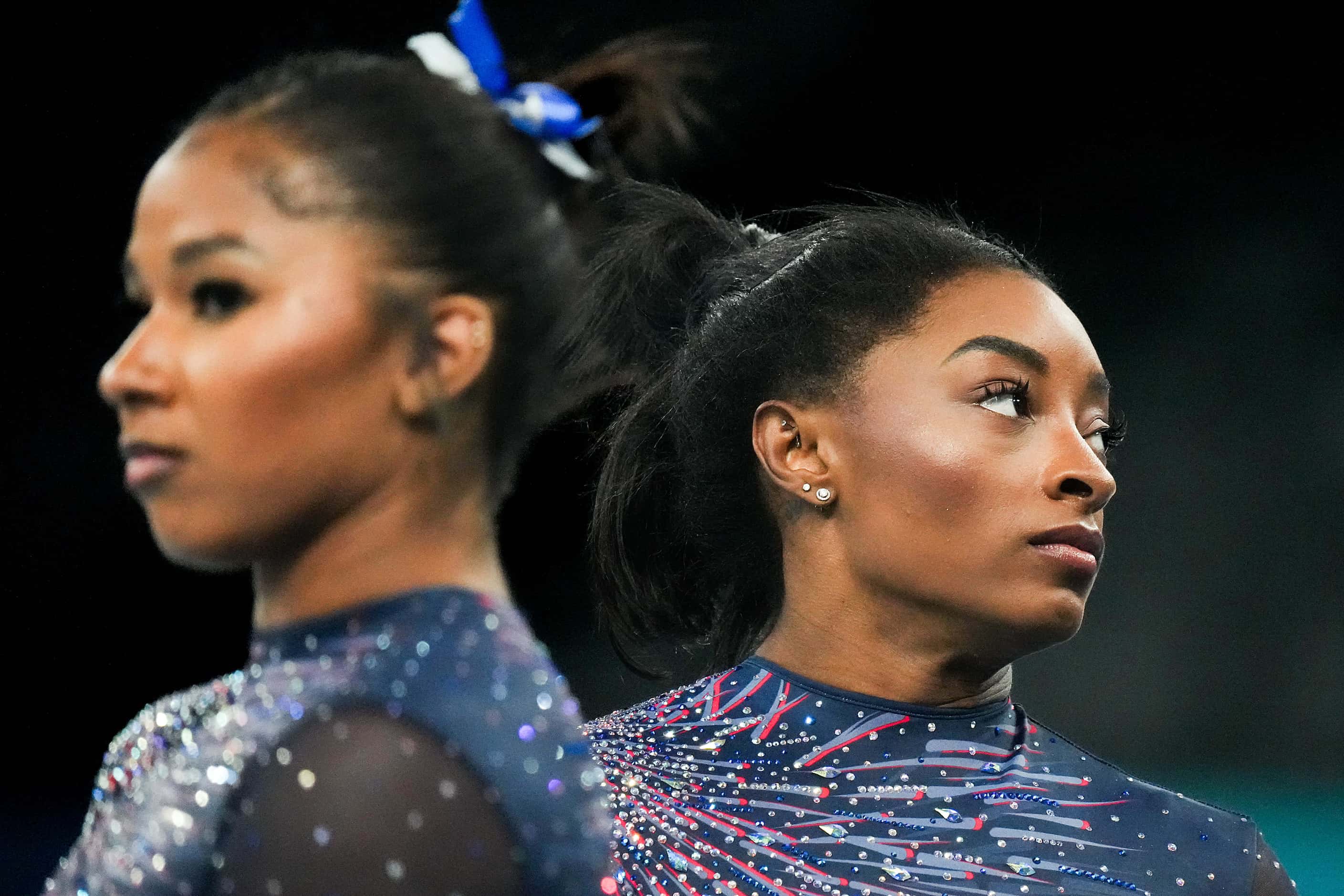 Simone Biles (right) and Jordan Chiles of the United States wait to practice on the uneven...