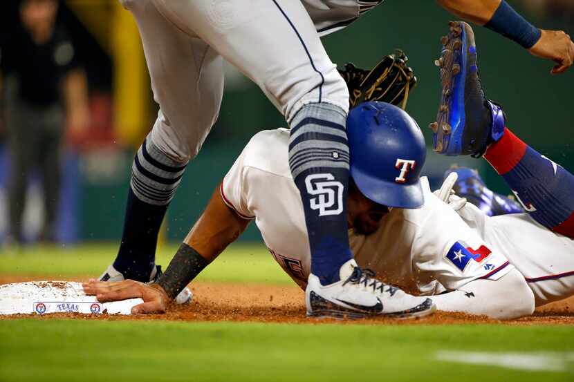 Texas Rangers Ronald Guzman collides with San Diego Padres third baseman Christian...