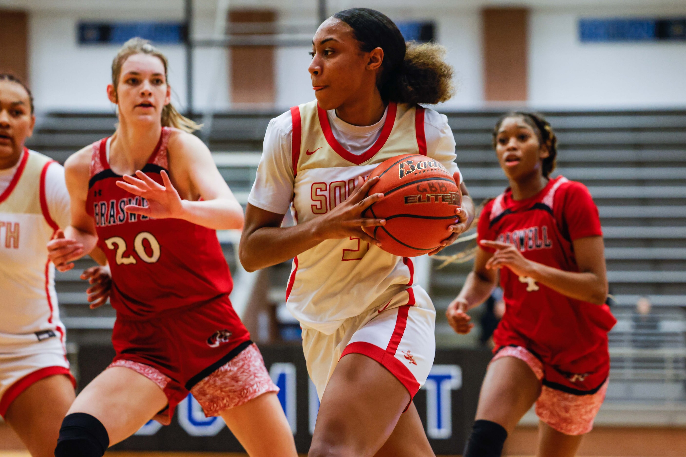 South Grand Prairie's Taylor Barnes (3) goes around Denton Braswell's Torie Sevier (20)...