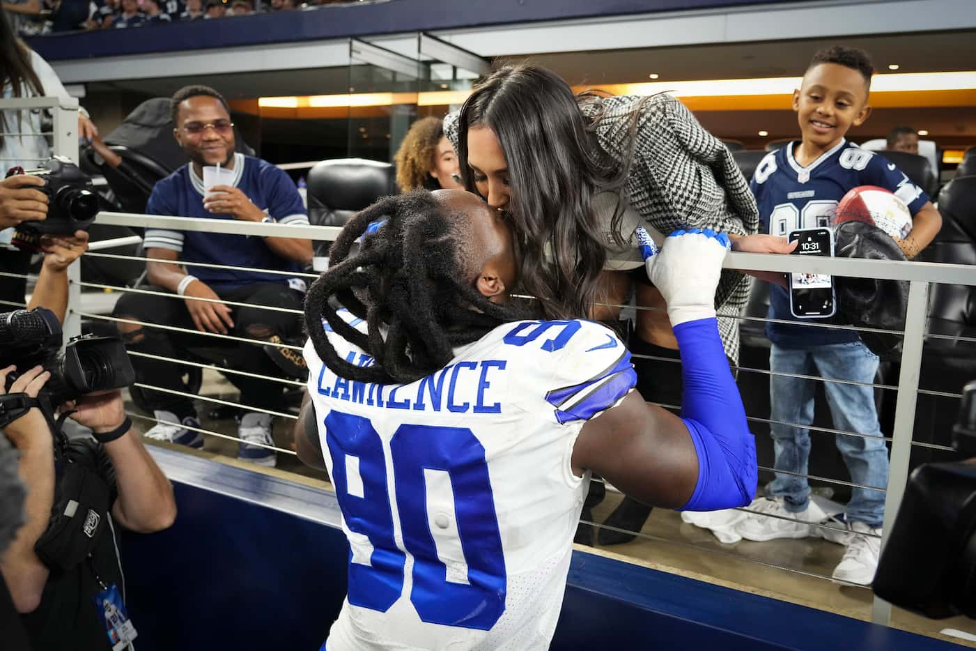 Dallas Cowboys defensive end Demarcus Lawrence (90) kisses his wife Sasha after handing the...