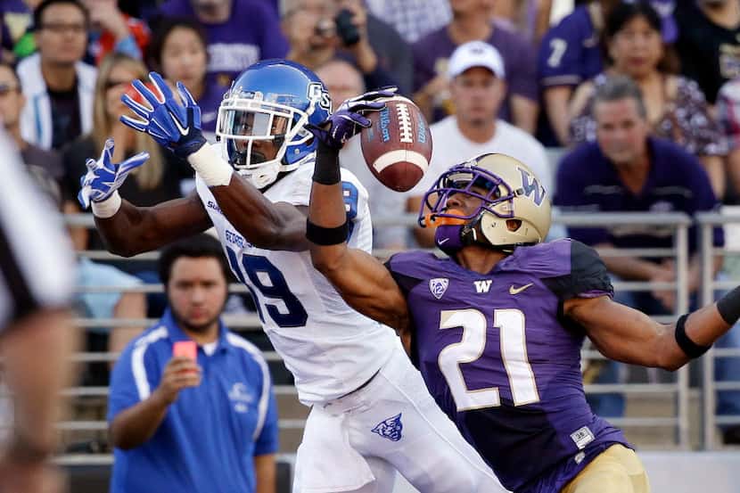 Washington's Marcus Peters (21) snags the ball in the end zone in front of intended receiver...