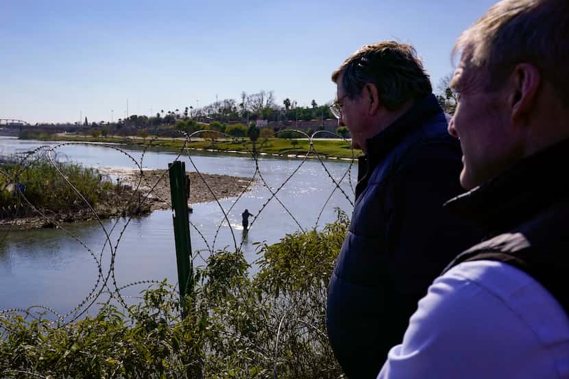 Republican members of Congress look on as migrants cross the Rio Grande at the Texas-Mexico...