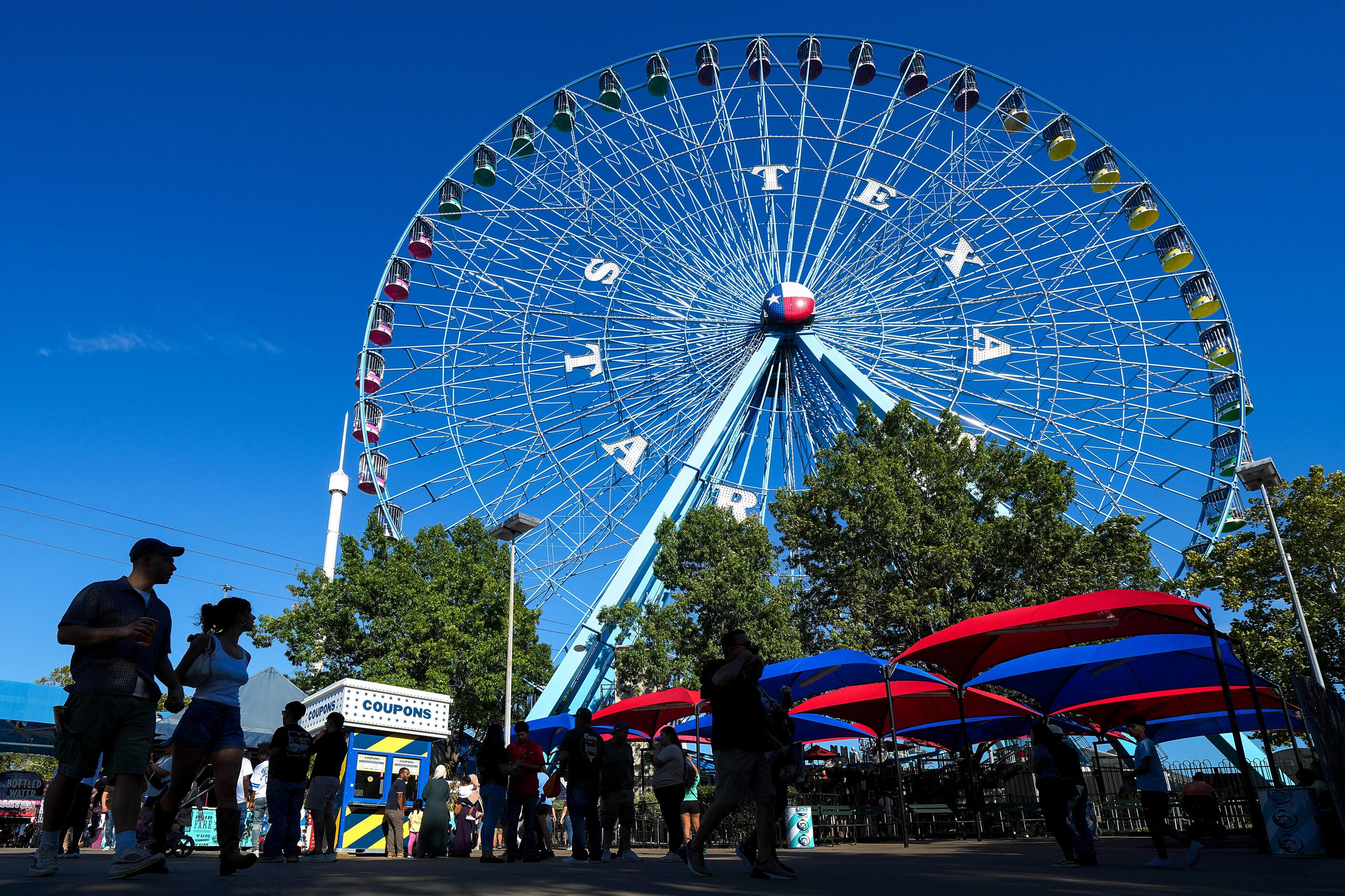 The Texas Star Ferris wheel rises over the midway at the State Fair of Texas on Sunday,...