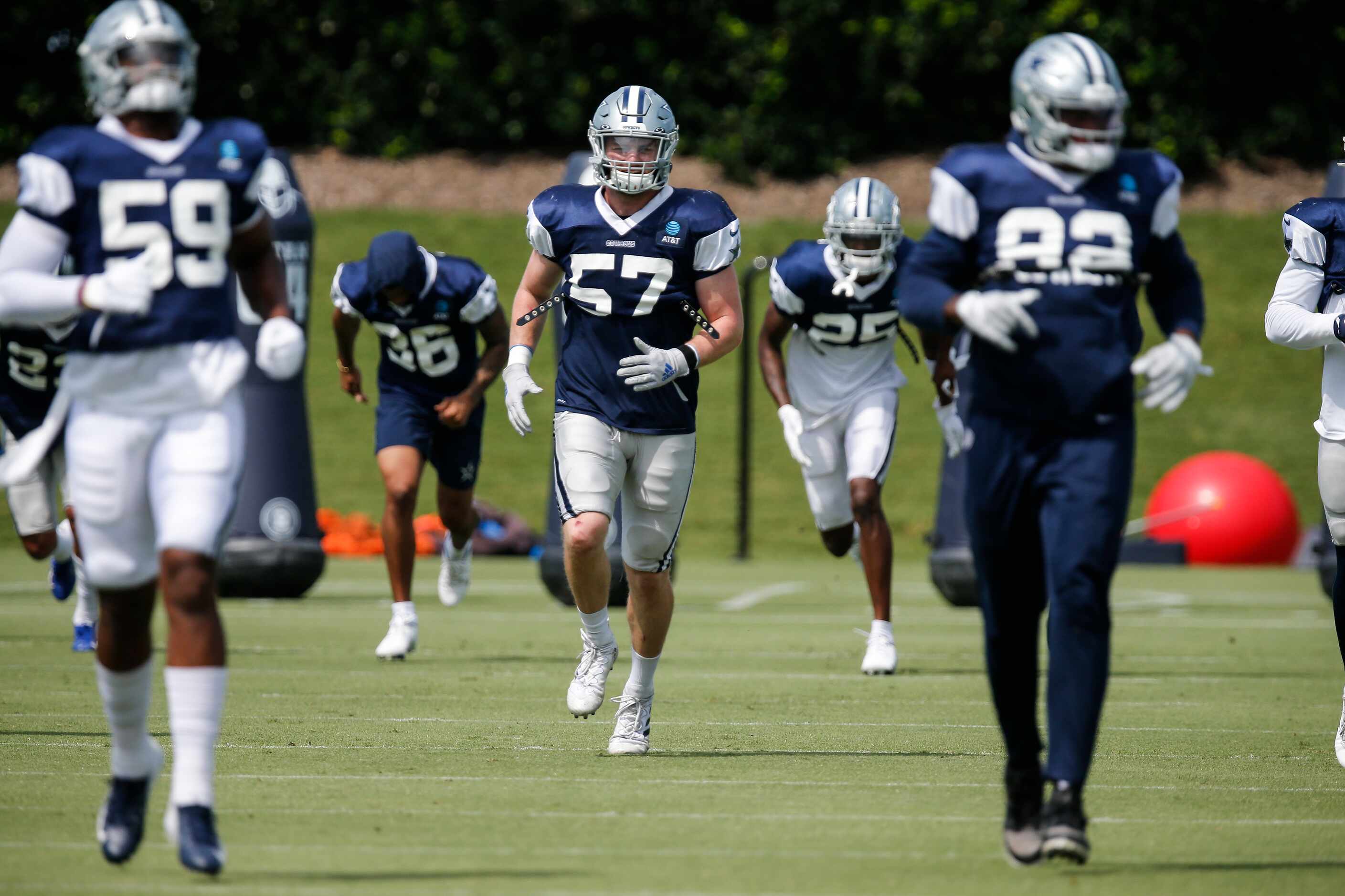 Dallas Cowboys linebacker Luke Gifford (57) and his teammates warm up during practice at The...