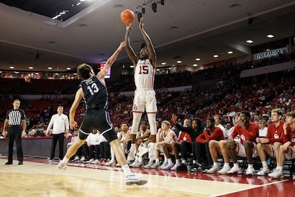 Oklahoma guard Duke Miles (15) shoots over Central Arkansas guard Ben Fox (13) during the...