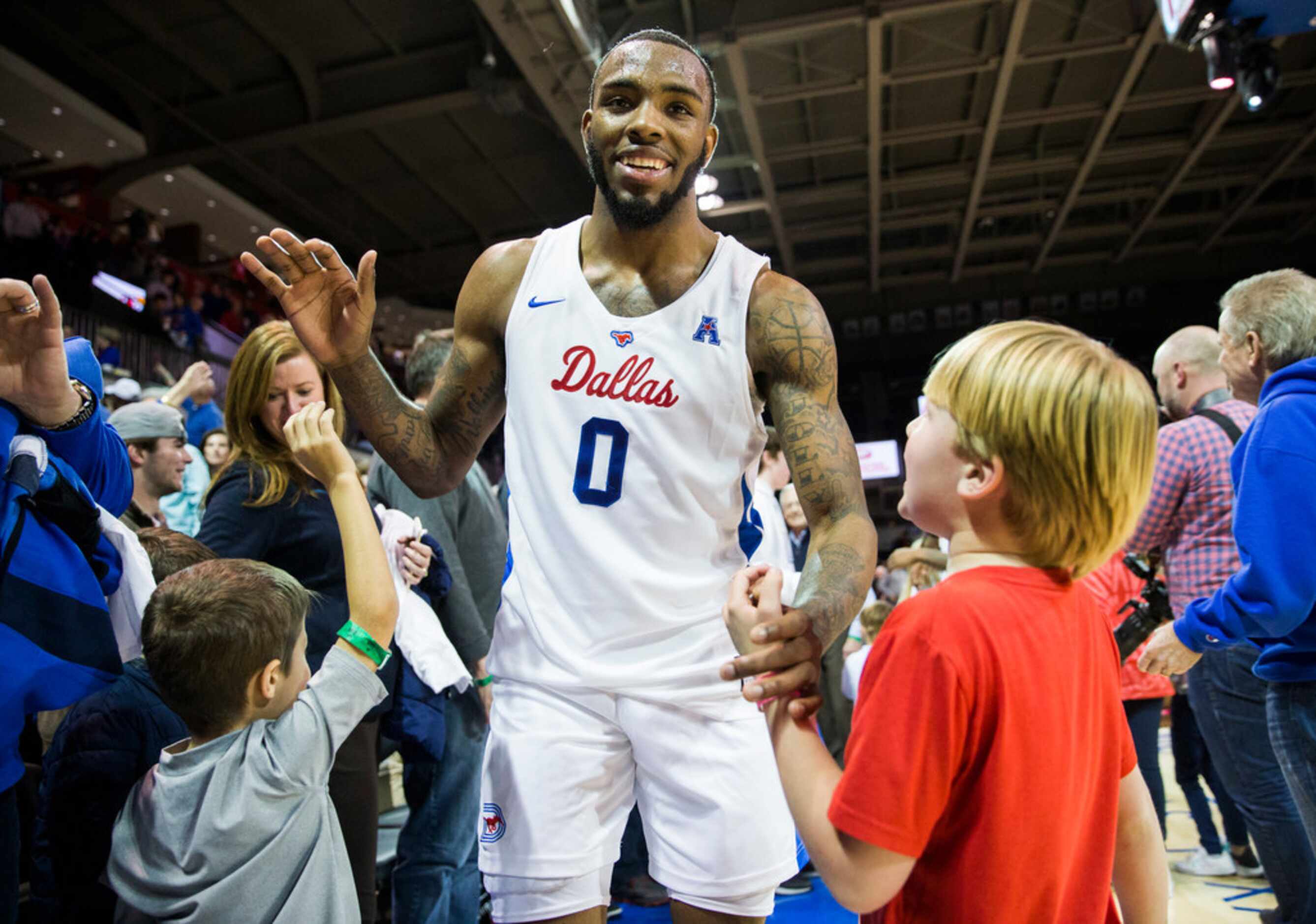 Southern Methodist Mustangs guard Tyson Jolly (0) high-fives fans after a 73-72 win in...