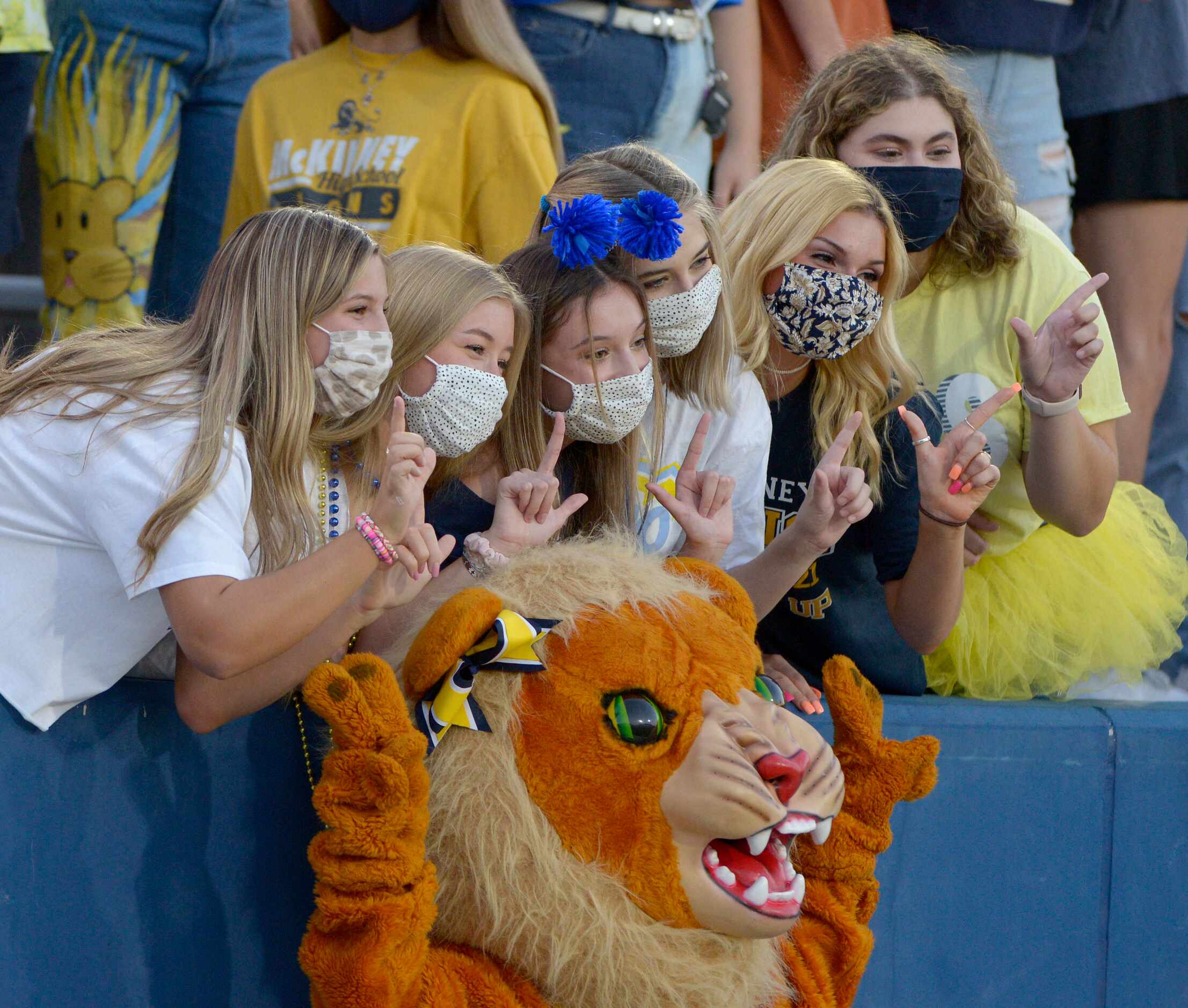 McKinney student pose for a photo with the Lion during a high school football game between...