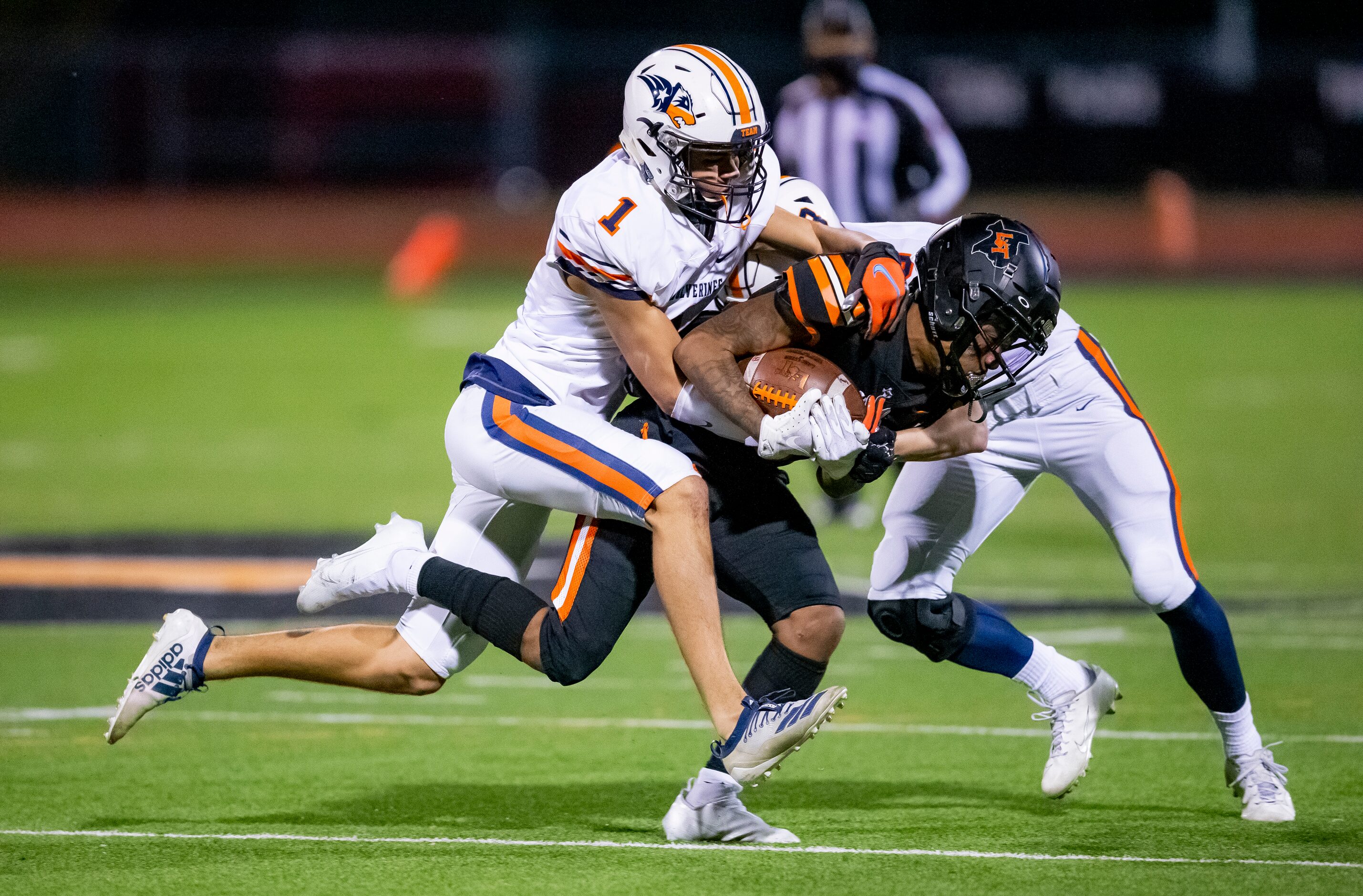 Lancaster senior wide receiver Majik Rector, center, is tackled by Wakeland junior defensive...