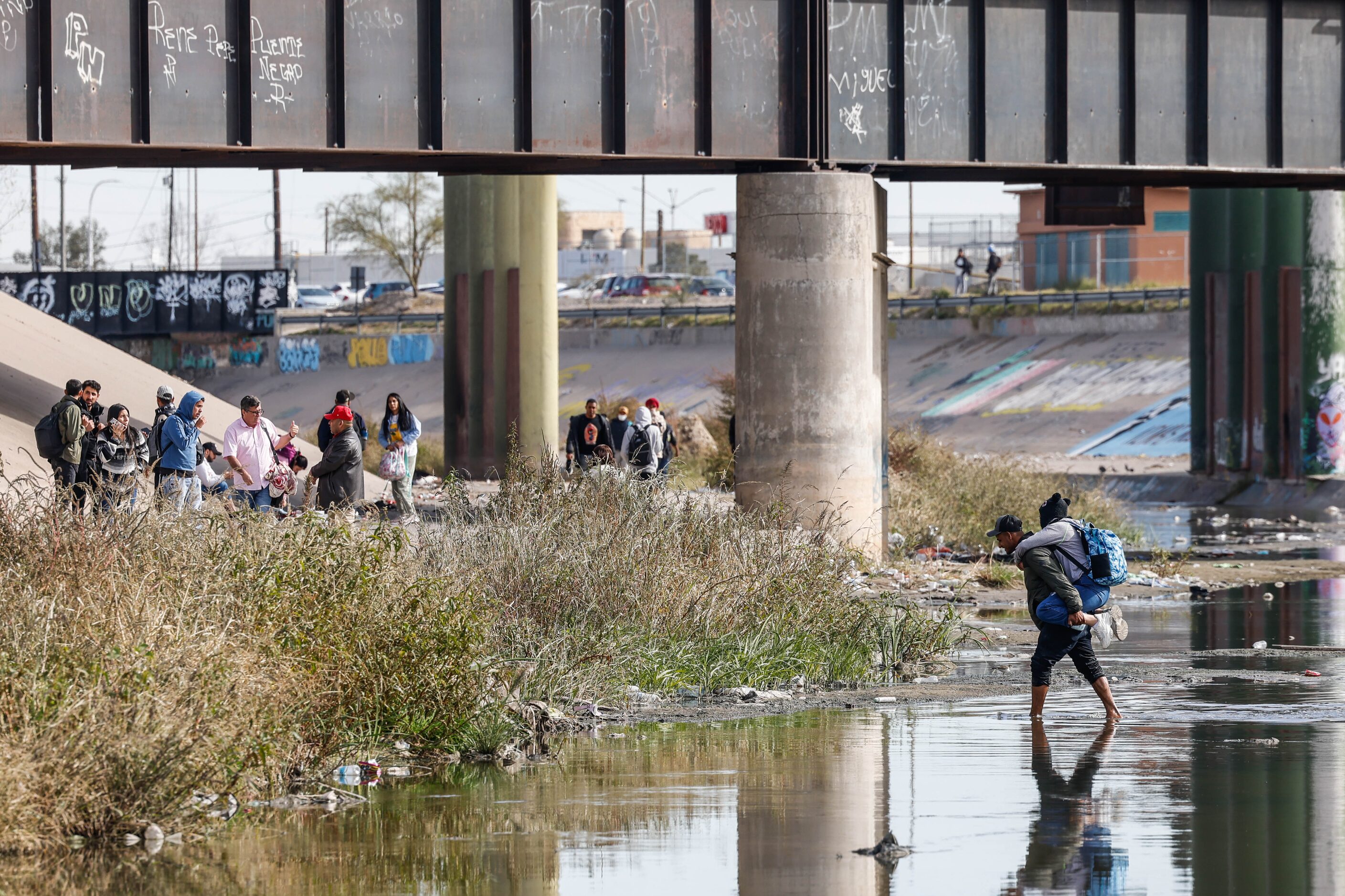 A migrant is carried across the Rio Grande river and into El Paso, Texas on the US-Mexico...