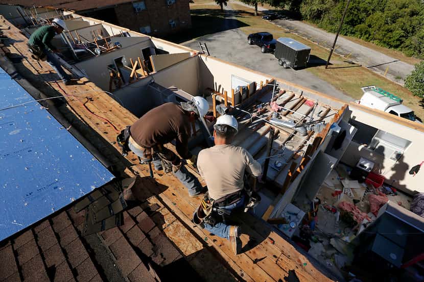 Crews worked to replace the roof of an Arlington Baptist College dorm damaged by a storm in...