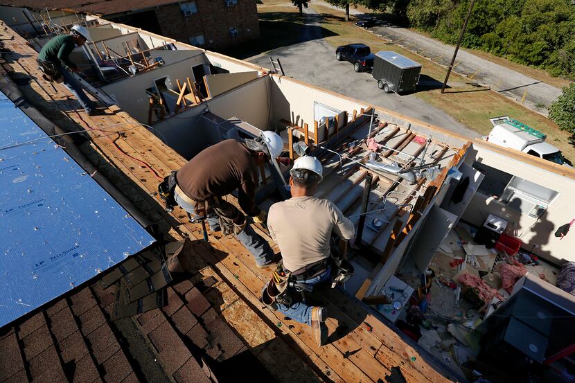 Crews worked to replace the roof of an Arlington Baptist College dorm damaged by a storm in...