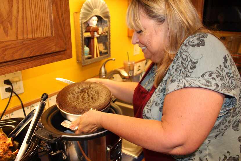 Santa Fe author Cheryl Alters Jamison pulls a chocolate cake out of her slow cooker. The...