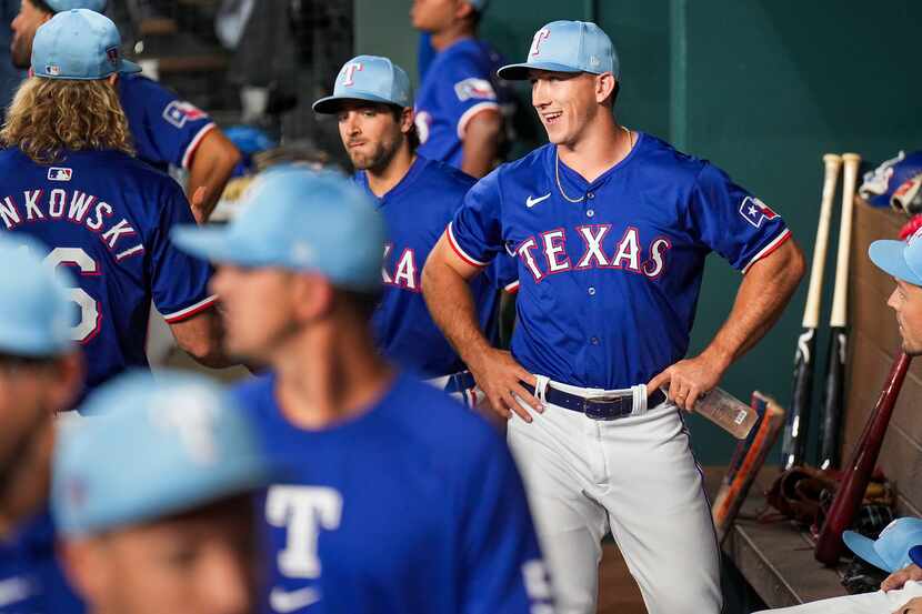 Texas Rangers outfielder Wyatt Langford laughs with teammates in the dugout before an...