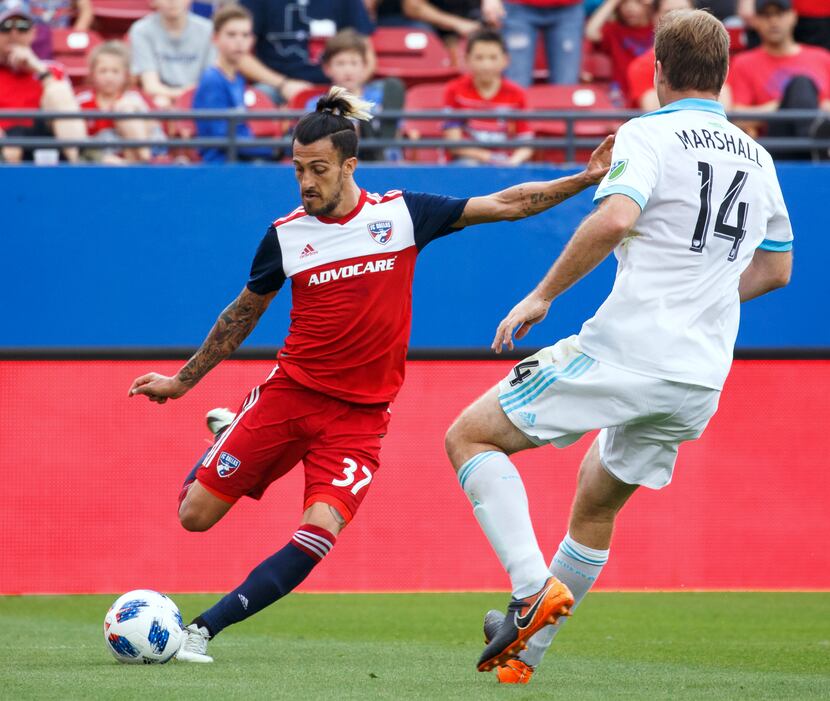Maxi Urruti of FC Dallas lines up to shoot past Chad Marshall of the Seattle Sounders....