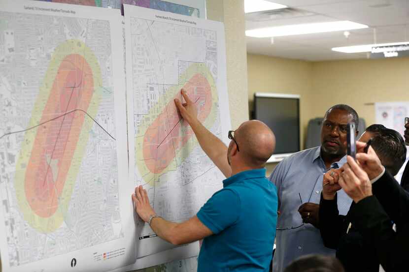 Daniel Cherry and other Dallas County officials look over a tornado weather map during a...