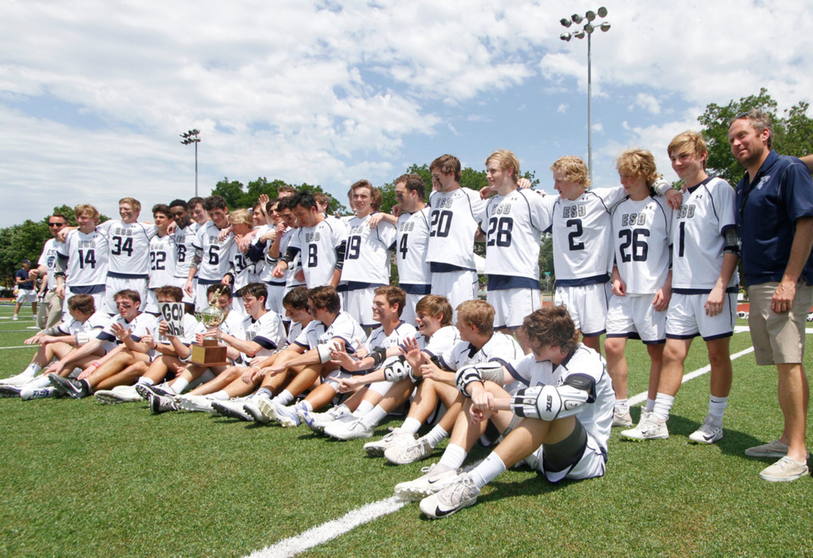 Members of the Episcopal School of Dallas lacrosse team pose with their championship trophy...