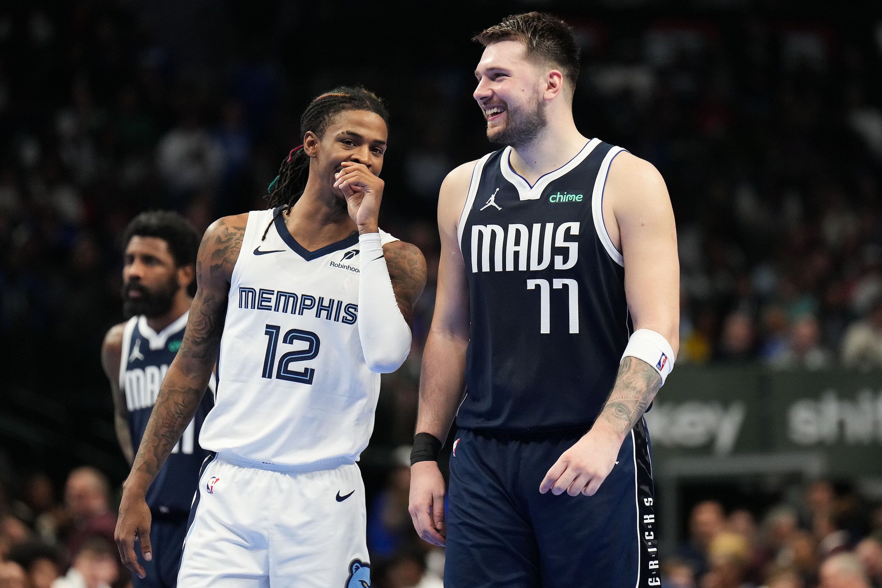 Dallas Mavericks guard Luka Doncic (77) laughs with Memphis Grizzlies guard Ja Morant (12)...