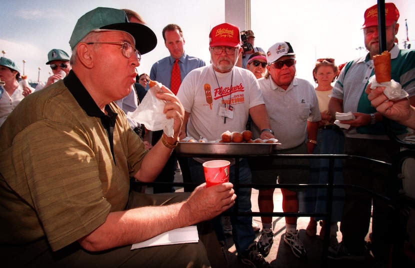 Mikhail Gorbachev (left) enjoys a corny dog as Skip Fletcher (center with white hat/shirt...