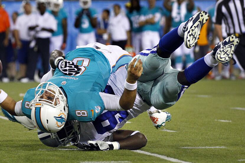 Cowboys defensive end George Selvie twists down Dolphins quarterback Matt Moore for a sack...