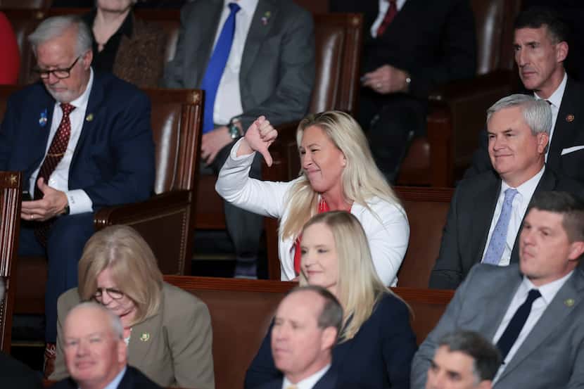Rep. Marjorie Taylor Greene, R-Ga., expresses disapproval with a thumbs-down gesture as...