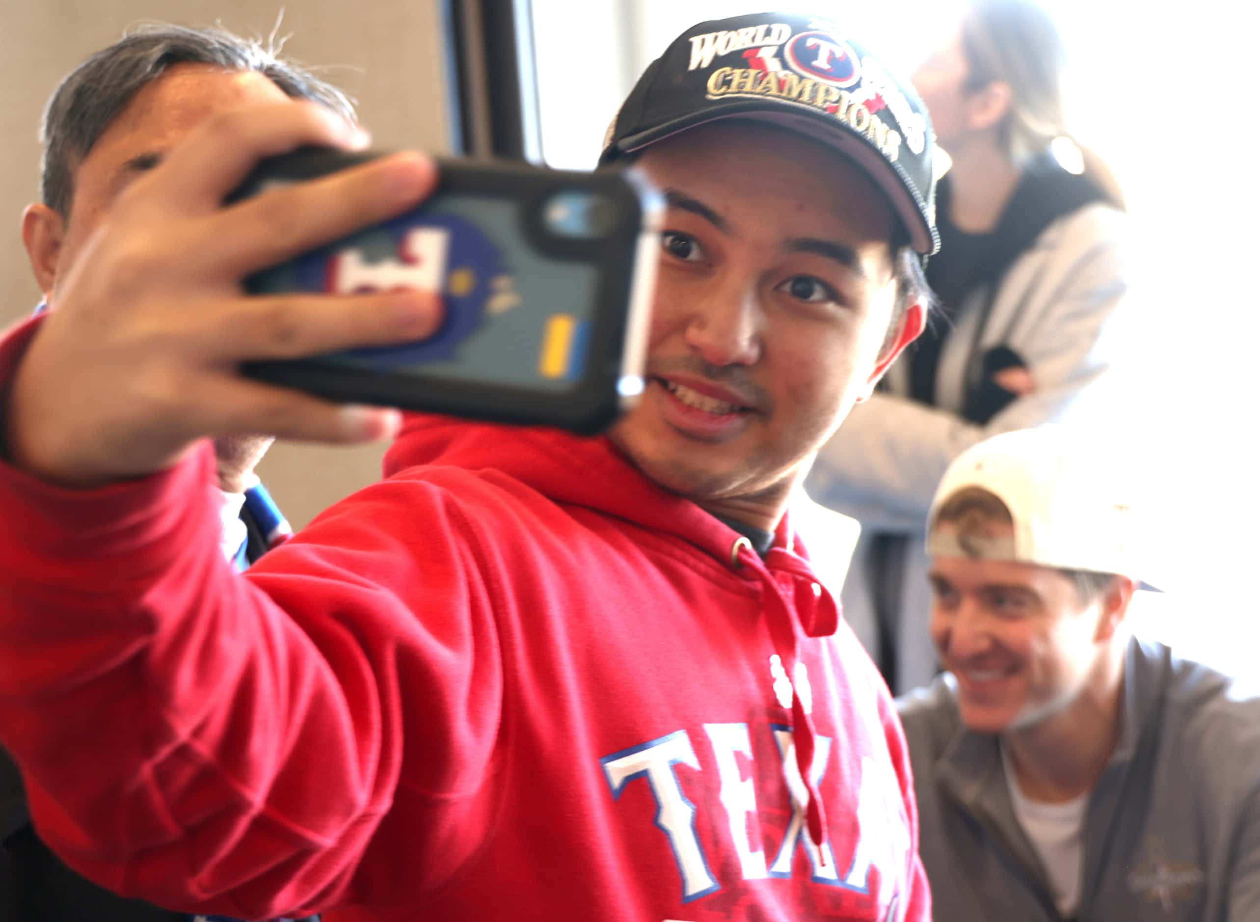 Texas Rangers fan Ynigo Villanueva records a selfie with Rangers pitcher Josh Sborz, lower...